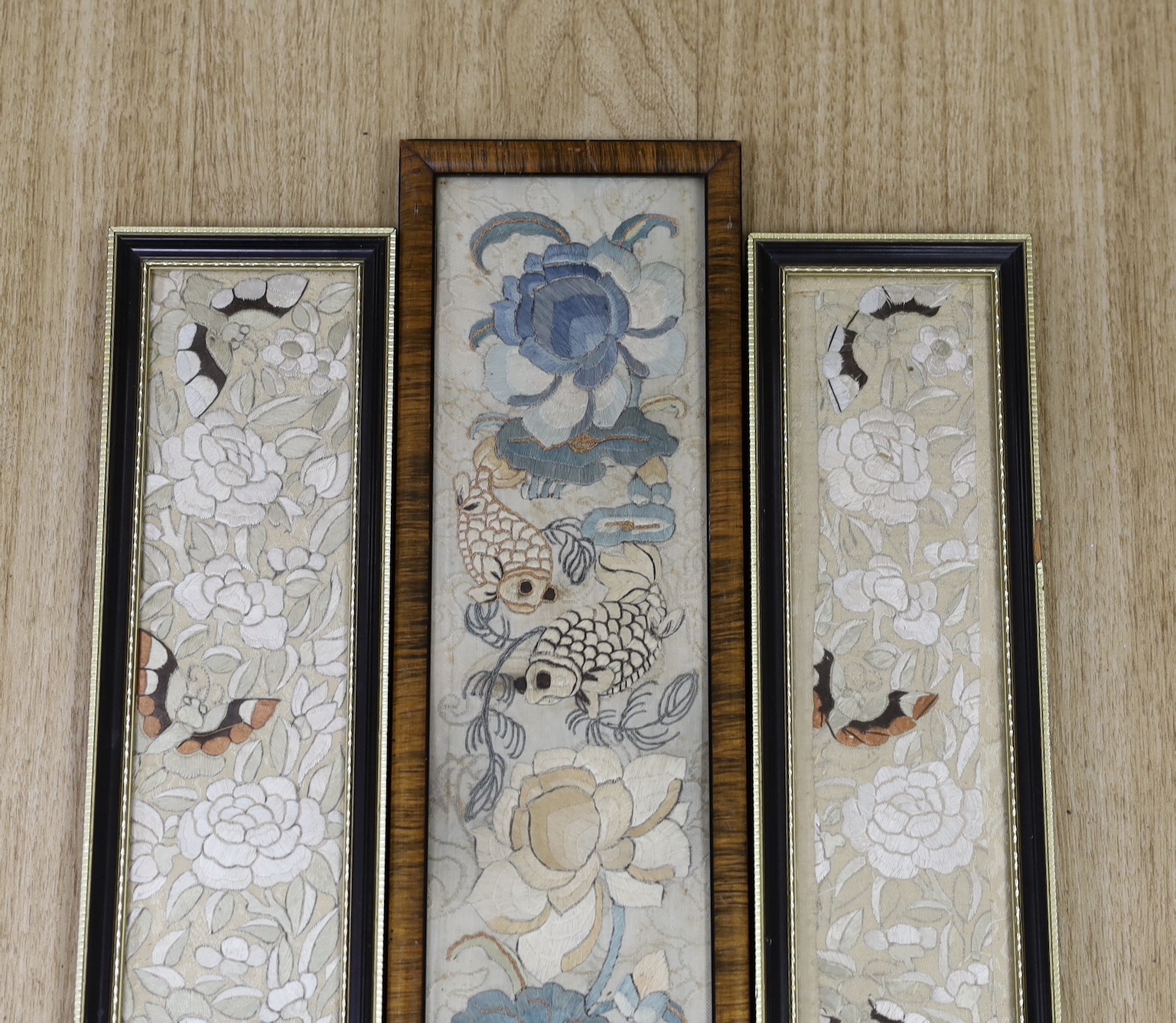 Three 19th century Chinese framed silk embroidered sleeve panels, largest 12 x 55cm